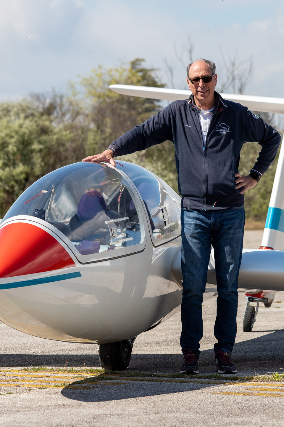 Pilota accanto all'aliante scuola sul punto attesa della pista dell'aeroporto di Boscomantico