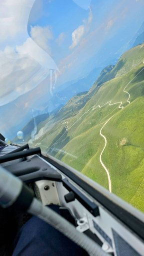 Paesaggio collinare visto dall'aliante con strada sinuosa tra le colline