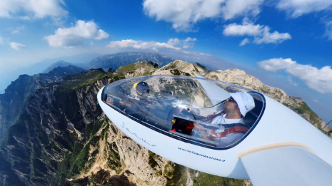 Vista esterna di un aliante in volo sulle montagne